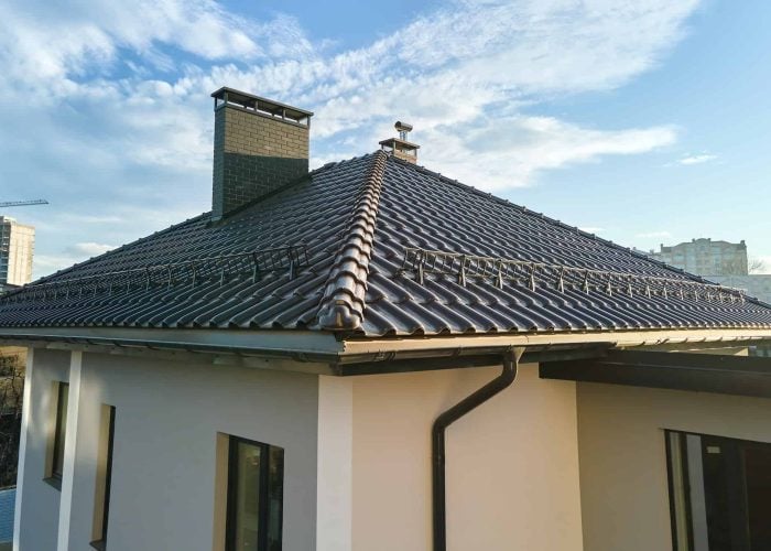 closeup-of-house-roof-top-covered-with-ceramic-shingles-with-gutter-pipes.jpg