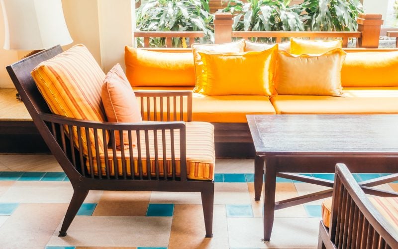 Empty wooden sofa with pillow and chair decoration in living room interior - Vintage Filter